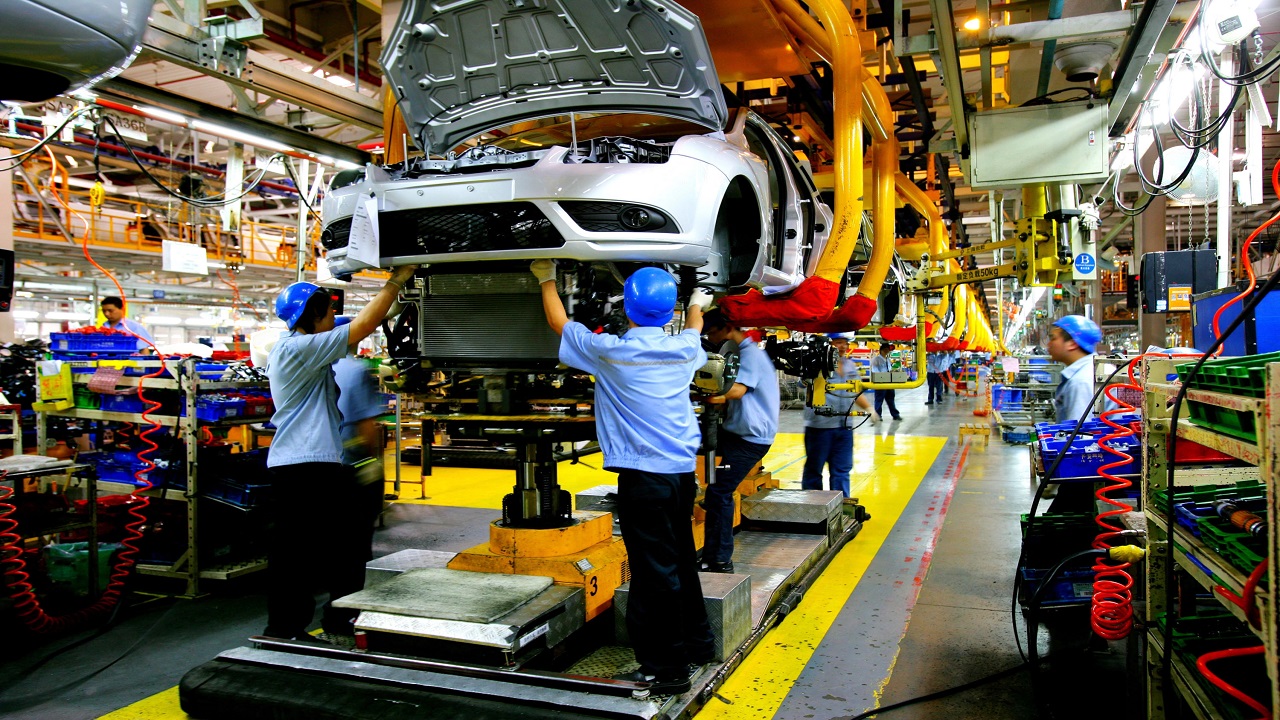 Chinese factory workers, auto engineers assemble Ford cars on the assembly line at the auto plant