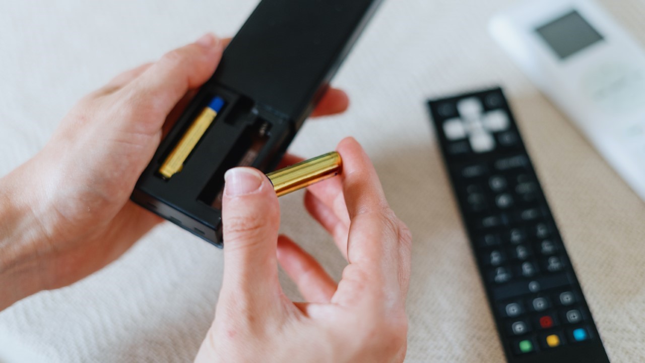 Battery, man fixing batteries to remote device