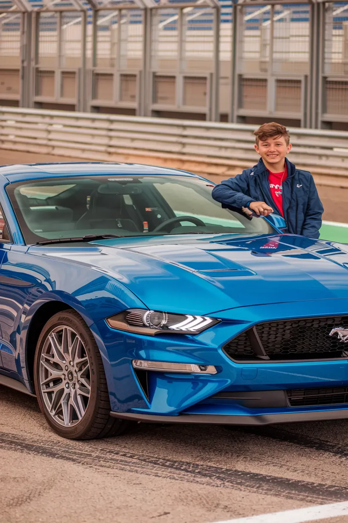 A blue Ford Mustang EcoBoost parked at a racetrack, showcasing its sporty design. 